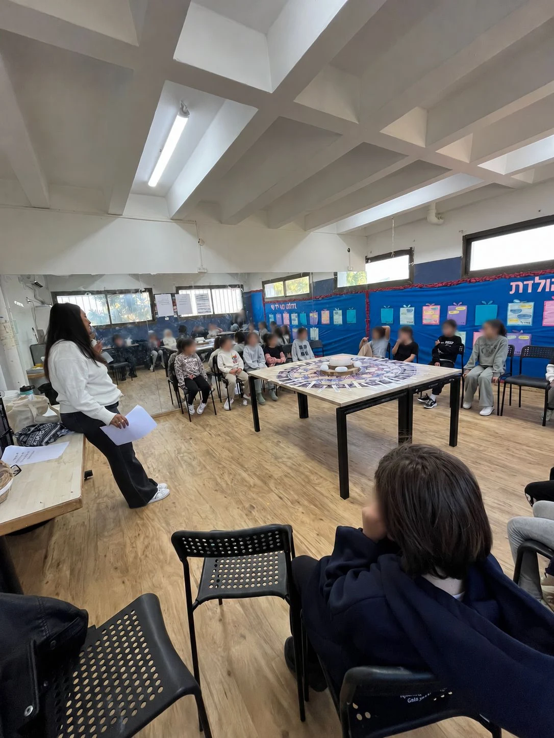 הילה מנחה פעילות קבוצתית בכיתה, עם טשטוש הפנים המקורי